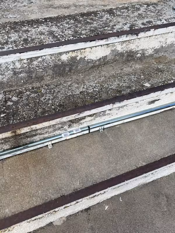 Conduit clamped along a concrete terrace